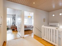 Näkymä yläkerran aulasta kahden makuuhuoneen suuntaan