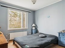 Suurimmassa makuuhuoneessa ikkunat ovat vehreälle takapihalle.