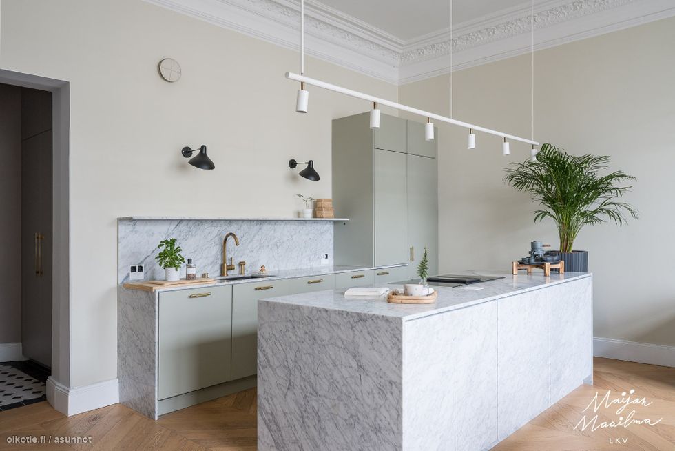 Avara ja tyylikäs keittiö ja ruokailutila näyttävällä marmorisaarekkeella.