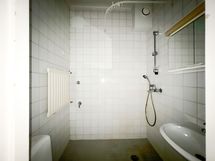 Laatoitettu kylpyhuone pesukoneliitännällä.