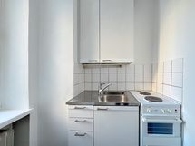 Kompaktissa keittokomerossa on myös ikkuna. Jenkkikaappi on sijoitettu huoneen puolelle.