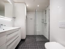 Tyylikkäästi laatoitettu kylpyhuone