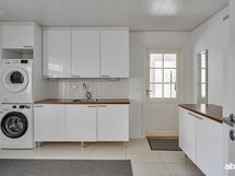 Kodinhoitohuoneeseen oma sisäänkäynti viileän kuistin kautta.