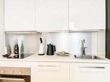 Moderni keittiö, josta löytyy mm.pienempi pöytämallinen astianpesukone.