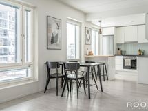 Vaaleasävyinen keittiö sijoittuu käytännöllisesti oleskelutilan toiseen päätyyn.