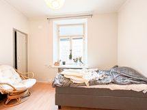 Huoneeseen mahtuu sänky sekä ruokapöytä ja muita huonekaluja.
