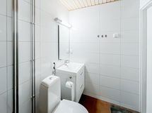 Kylpyhuone on siisti ja laatoitettu.