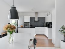 Kodin moderni keittiö yhdistyy olohuoneeseen käytännölliseksi kokonaisuudeksi.