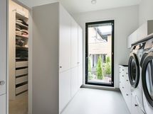 Tilava ja tyylikäs kodinhoitohuone sekä walk-in-closet.
