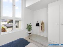 Korkea tila ja isot ikkunat tekevät makuuhuoneesta ateljeemaisen avaran.