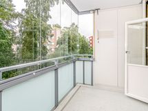 Tilava lasitettu parveke sisäpihan suuntaan länteen.