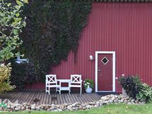 Kesäsaunan sisäänkäynti autotallin päässä