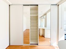 Huoneessa on lattiasta kattoon ulottuvat liukuovikaapistot.