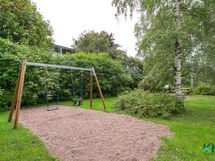 Taloyhtiön piha-aluetta - lasten keinut ja leikkipaikka, kesäkuva