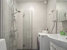 Kylpyhuone on muun kodin tavoin tyylikäs, varustettu lattialämmityksellä ja myös pesukone mahtuu.