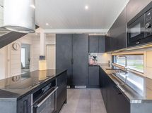 Minamalistinen ja toimiva keittiö, jossa kaikki on käden ulottuvilla.