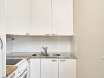 Keittokomerossa siistit kaapistot ja nykyaikaiset kodinkoneet.