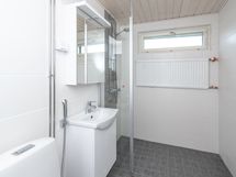 Ikkunallisessa kylpyhuoneessa suihku, sadettajasuihku, allas ja bide sekä pesukoneliitäntä.