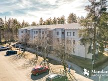 Kerrostalo etupihan parkkipaikka-alueelta päin.