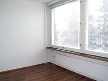 Tilava makuuhuone, jossa isot ikkunat.