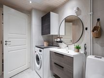 Kylpyhuoneessa on myös taso pesukoneen päällä sekä seinäkaappi ja allaskaapisto