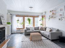 Tilava olohuone isoilla ikkunoilla ja varaavalla takalla