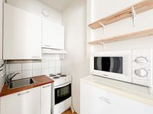 kompakti keittonurkkaus, jossa sähköliesi, mikro ja jenkkikaappi.