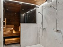 Saunassa on SPA-tunnelmaa epäsuoran valaistuksen ansiosta. Kaksi sadesuihkua helpottaa arkea.