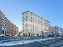 Taloyhtiö seisoo jykevästi omalla tontillaan.