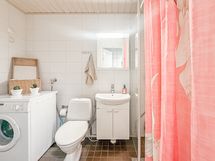 Tilava laatoitettu kylpyhuone hyvällä suihkutilalla sekä pesukoneliitännällä.