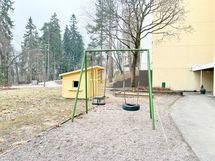 Pihalla on lasten leikkitelineitä.