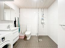 Tilavaan kylpyhuoneeseen mahtuu täyslevyinen pyykinpesukone.