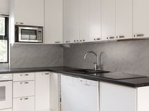 Keittiö on ajan henkeen selkeä ja vaalean harmaa