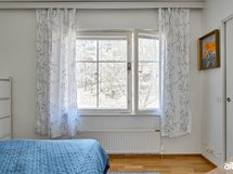 Makuuhuoneen ikkunasta aukeaa metsämaisema.