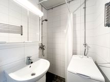 Perällä suihku sekä paikka pyykinpesukoneelle.