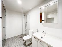 Tilava laatoitettu kylpyhuone, jossa hyvä suihkutila, ja lattialämmitys.