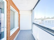 Lasitettu parveke, joka lisää tilan tuntua ja toimii suuren osan vuodesta extrahuoneena.