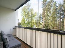 Olohuoneen lasitettu parveke länteen puistomaisemin.
