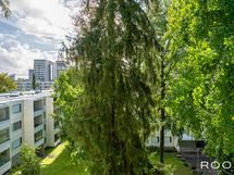 Lasitetun parvekkeen näkymää taloyhtiön vehreälle piha-alueelle.