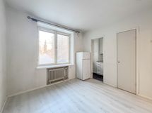 Asunnossa on yhtenäinen vaaleanharmaa laminaattilattia ja maalatut seinät.