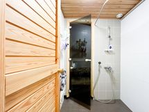 Puuoven takaa on käynti kylpyhuoneeseen, joka on laatoitettu.