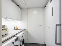 Sisääntulokerroksen kodinhoitohuone. Tekniikkatila on oven takana