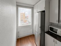 Ikkunallinen keittokomero, jonne mahtuu myös pieni pöytä tuoleineen.