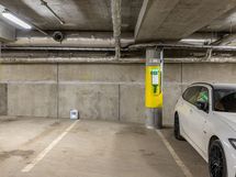 Autohallipaikka, jossa sähköauton latauslaite