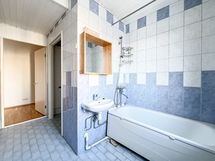 Kylpyhuoneen perällä on amme ja suihku.