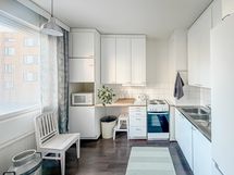 Tilava ikkunallinen keittiö, jonne mahtuu myös ruokapöytä.