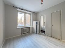 Asunnossa on yhtenäinen vaaleanharmaa laminaattilattia ja maalatut seinät.