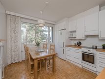 Remontoitu keittiö, jossa on runsaasti kaappitilaa ja tilaa ruokapöydälle