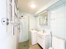 Kylpyhuoneessa on paikka pyykinpesukoneelle ja pesukone jo valmiina.