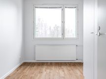 Pienempi makuuhuone oven lähellä.
